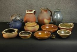 A large collection of art pottery, including two stone ware jugs, various lidded pots, a blue