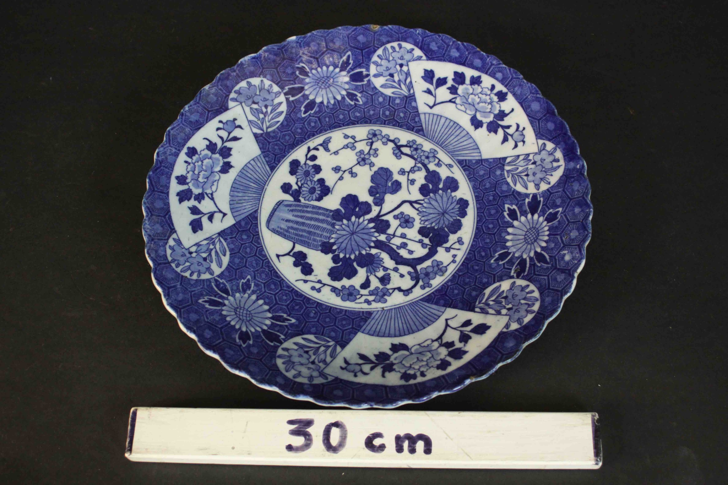 A large 19th century Japanese blue and white scalloped edge ceramic charger with transfer design - Image 2 of 6