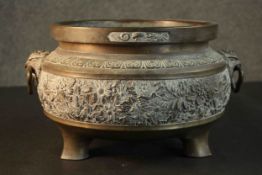 A Chinese 19th century brass censer with relief floral and foliate design, twin dragon handles and