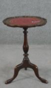 A reproduction wine table, the pie crust top with a tooled burgundy leather inset on a baluster