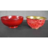 Two Chinese cinnabar lacquered bowls, one moulded with a temple and landscape design and brass