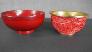 Two Chinese cinnabar lacquered bowls, one moulded with a temple and landscape design and brass