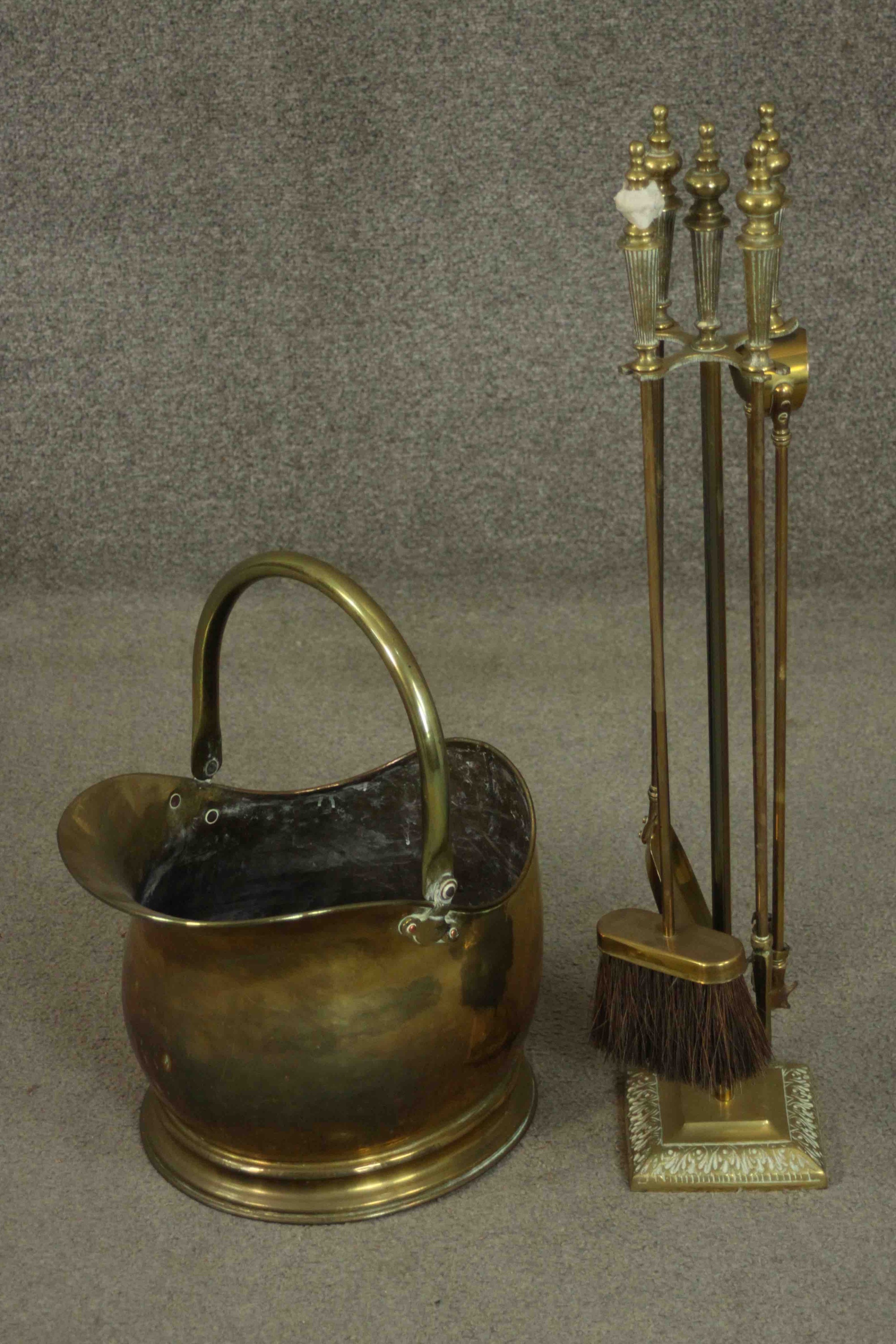 A Victorian brass coal bucket with a swing handle, together with a brass fireside companion set