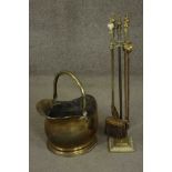 A Victorian brass coal bucket with a swing handle, together with a brass fireside companion set
