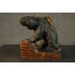 A Black Forest carved bear and salmon, on a carved plinth base. H.32 W.30 D.16cm.