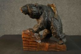 A Black Forest carved bear and salmon, on a carved plinth base. H.32 W.30 D.16cm.