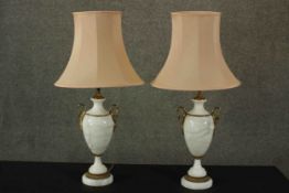 A pair of 20th century white marble amphora form table lamps, with gilt metal swan neck handles