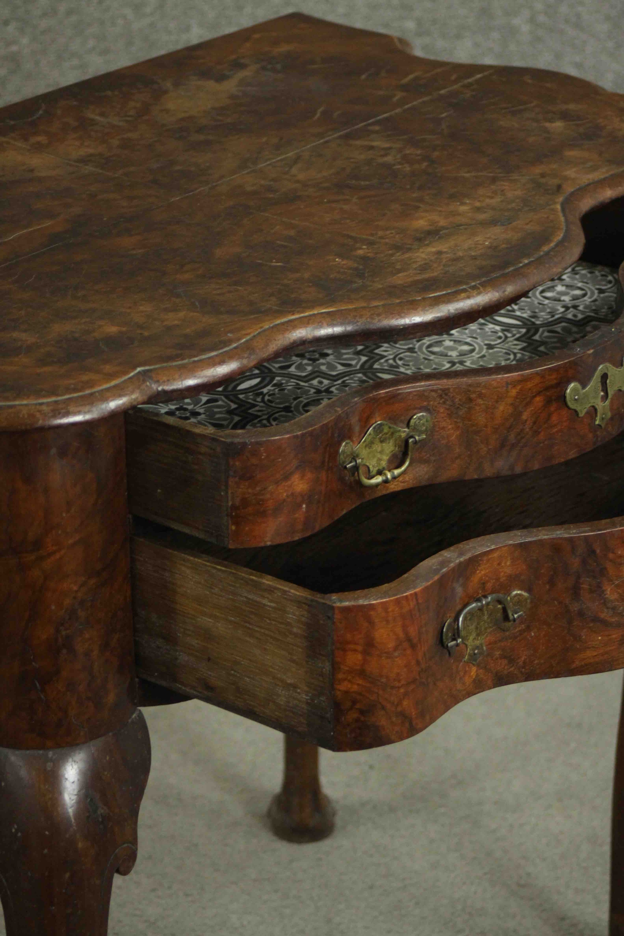 An early 18th century figured walnut lowboy of serpentine form, the top with a moulded edge over two - Image 5 of 8