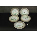 A set of eleven 19th century hand painted porcelain plates with pierced gilded lattice work rims and