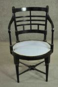 A Victorian ebonised Aesthetic movement open armchair, the circular seat upholstered in pale grey/