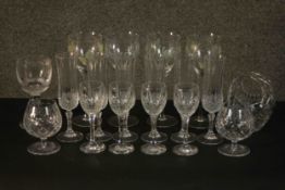 A collection of hand cut glass and crystal drinking glasses, including a set of six champagne