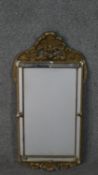 A 19th century carved giltwood and gesso pier mirror with shell cresting above cushion style