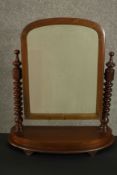 A Victorian walnut dressing table or toilet mirror, of rounded arch form supported by bobbin