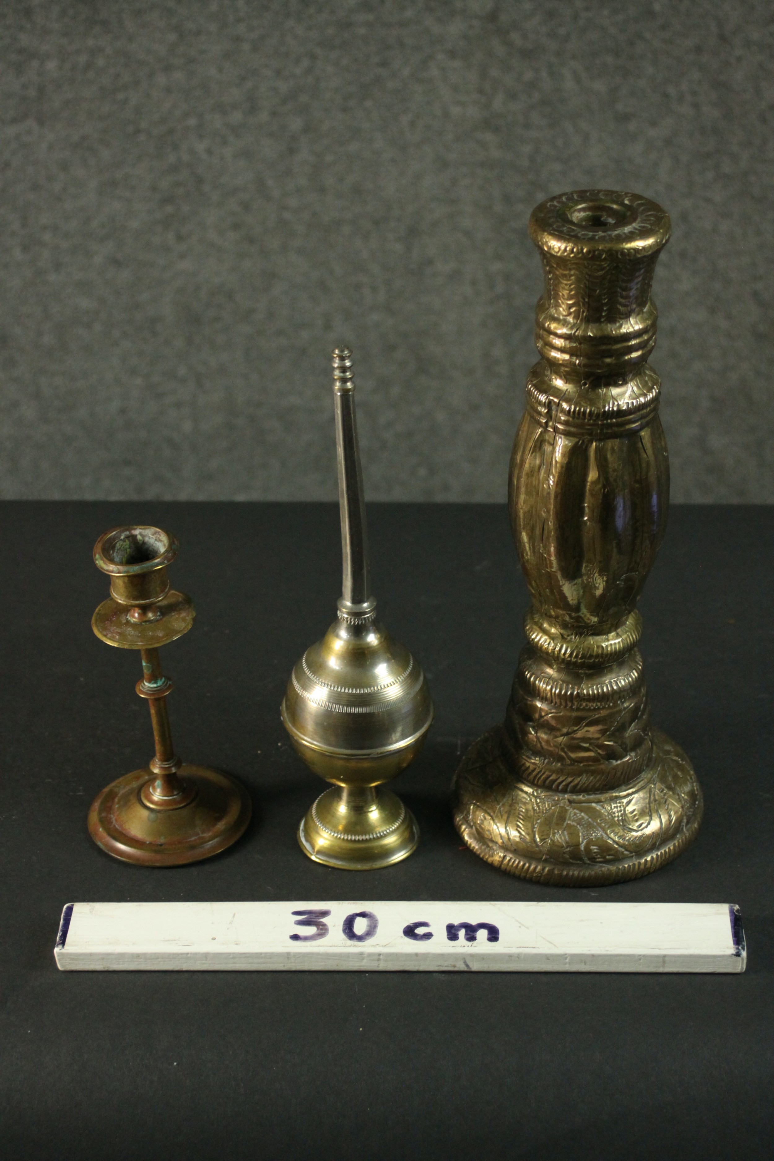 Three Indian brass items, comprising an ornately decorated candlestick, another candlestick, and a - Image 2 of 6