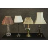 A collection of four table lamps with shades, including one formed from a brass candlestick, a