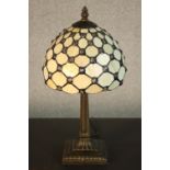 A reproduction Tiffany style table lamp, with a dome shaped stained glass shade on a columnar