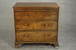 A George III mahogany bachelors chest, with a brushing slide over three long graduated drawers on