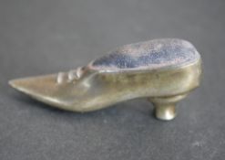 A silver pin cushion in the form of a heeled shoe. H.2cm. 22g