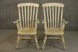 A pair of late 20th century oak Windsor carver chairs, with a comb back above a shaped seat on