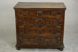 A 17th century and later Jacobean oak chest of four long drawers with geometric moulding and brass