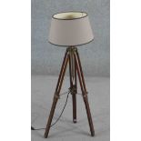 A vintage style tripod form standard lamp, with adjustable legs and brass mounts, with a shade. H.