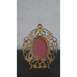 A Victorian cast gilt metal photograph frame, with an oval aperture, the frame formed of scrolling