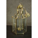 A George III style hexagonal brass hall lantern, with rectangular bevelled glass sides, containing