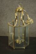 A George III style hexagonal brass hall lantern, with rectangular bevelled glass sides, containing