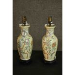 A pair of Chinese Famille Rose baluster table lamps, decorated with foliate designs, on ebonised