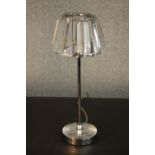 A table lamp with a prismatic glass shade, on a tubular chromed stem with a circular base. H.37