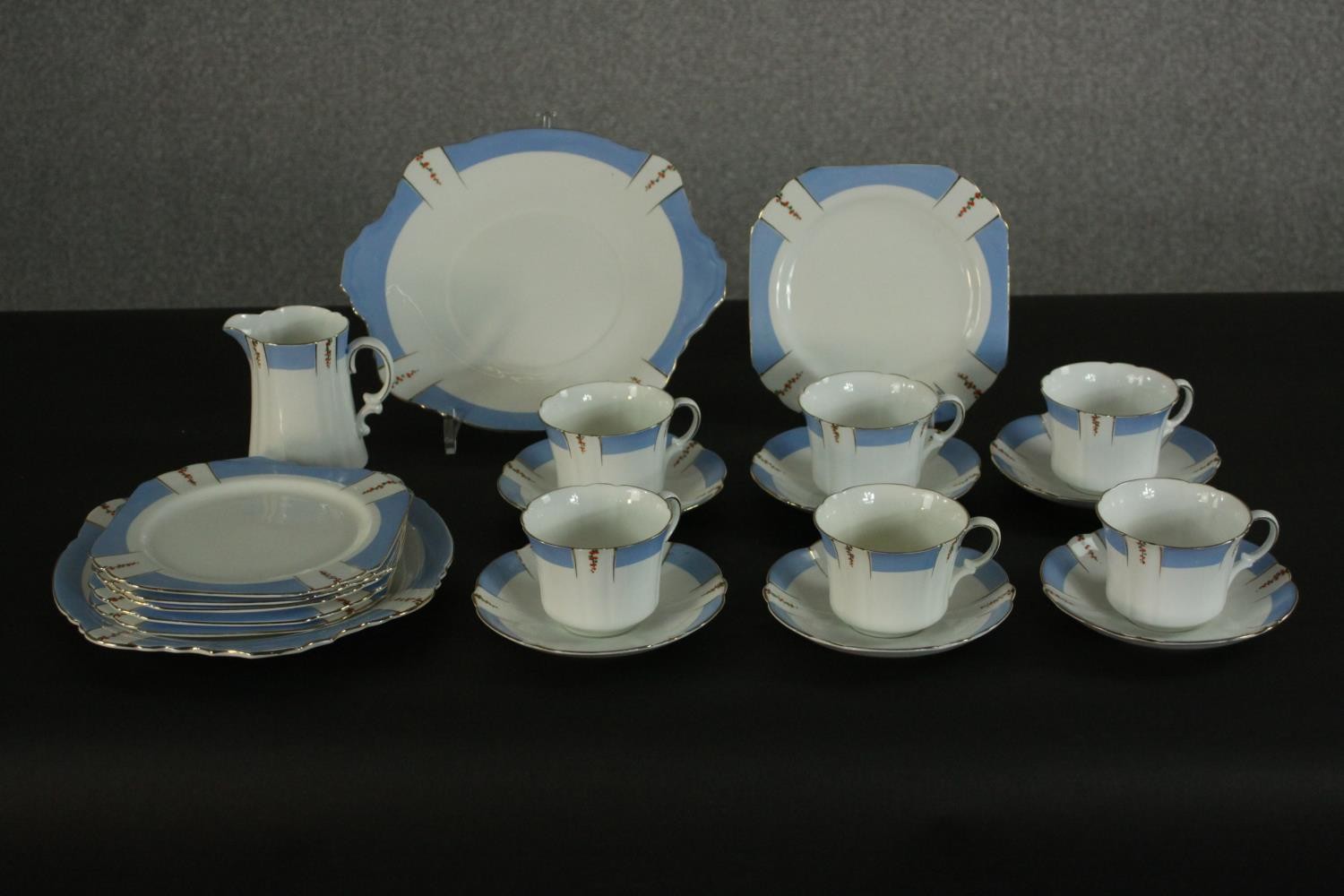 A Heathcote China part tea set, the blue border decorated with trails of flowers. Dia.16cm. (