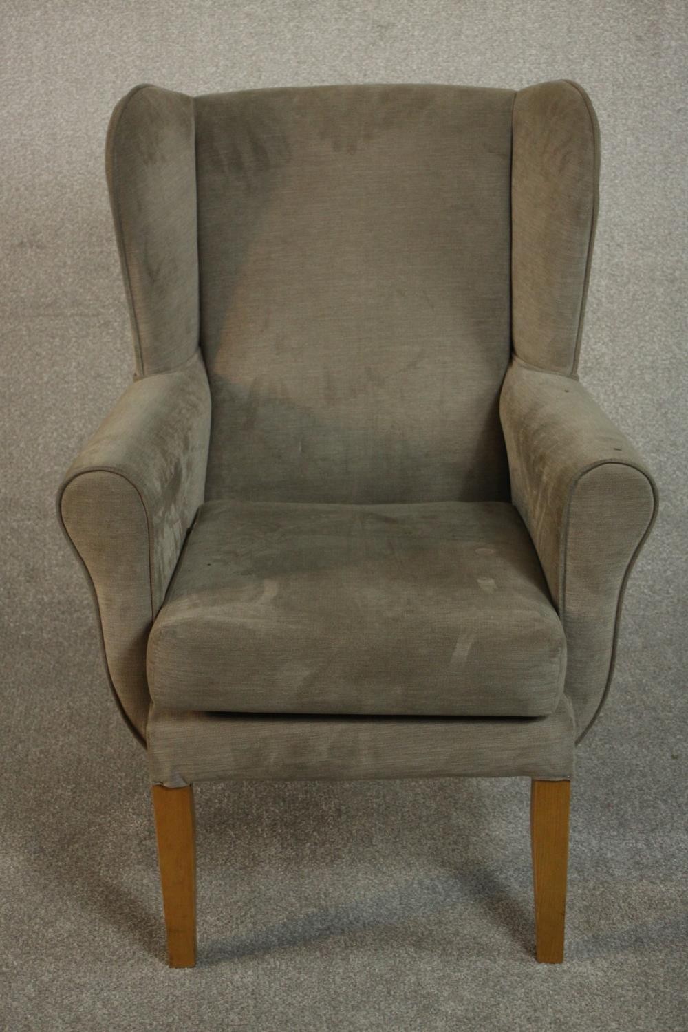 A contemporary wingback armchair in velour upholstery.