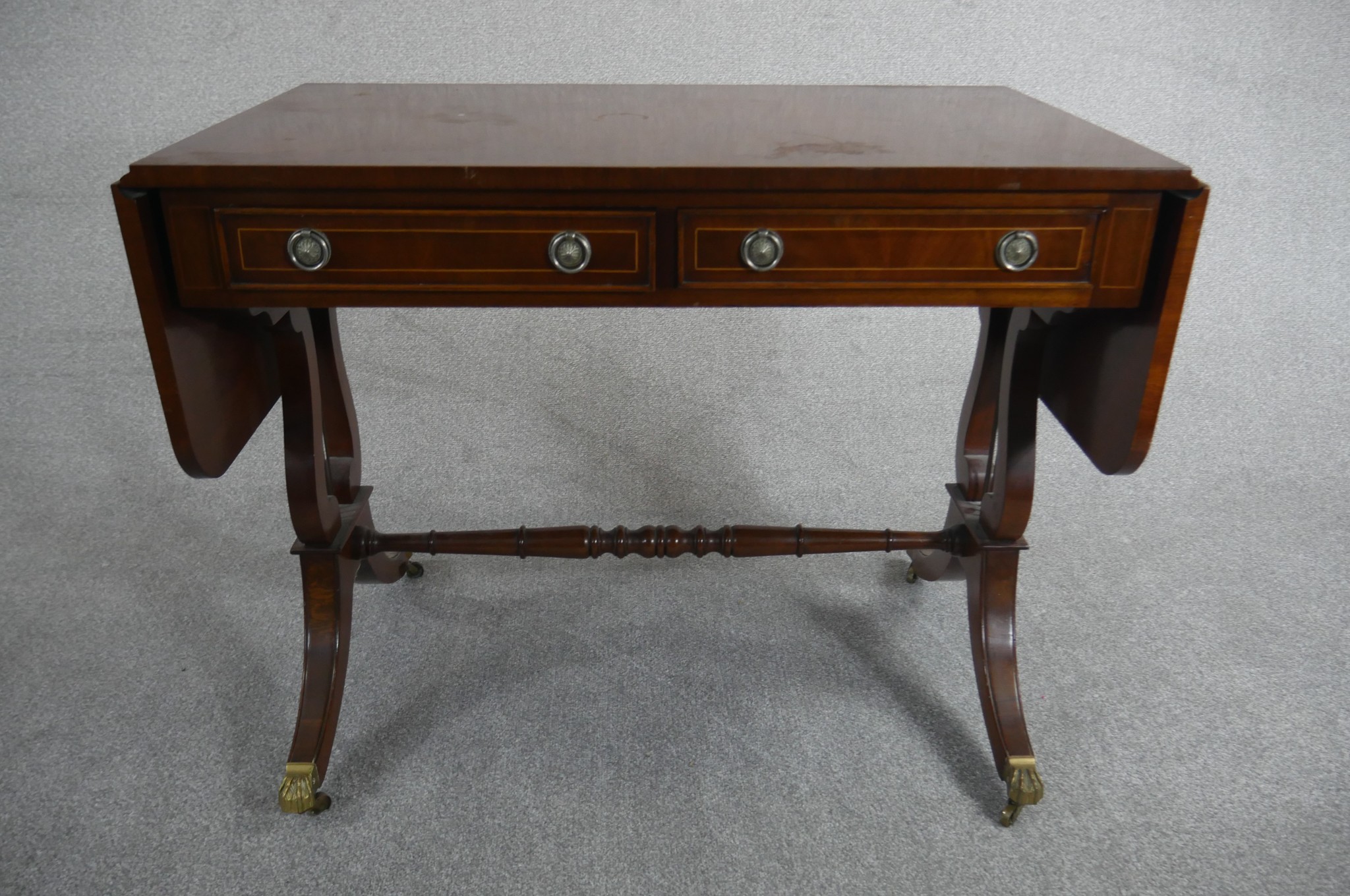A George III style reproduction mahogany sofa table, with two drop leaves and two short drawers on