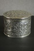 A large round repousse design Pakistani silver box with lid. All over decorated with a dragon,