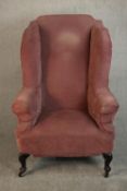 A 19th century wingback armchair, upholstered in pink velour with scrolling arms, on ebonised