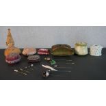 A collection of vintage pin cushions, hat pin holders and hat pins. Pin cushions include a beaded
