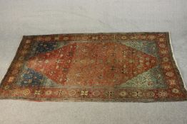 A Persian Sarouk rug with all over floral design on a burgundy ground within spandrels and