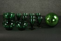 A set of eight dark green conical design liqueur glasses, a set of six green glass bowls and a