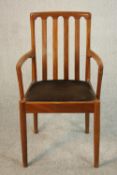 A Meredew teak carver, with a brown upholstered seat on cylindrical legs, label to the underside.