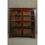 A 19th century mahogany bookcase, the two glazed doors with arched gothic tracery enclosing