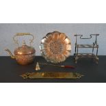 A collection of brass and copper, including a brass door plate, copper floral design plate and