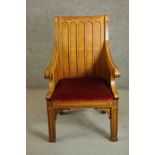 An early 20th century gothic revival oak armchair, the square back with rounded arch decoration over