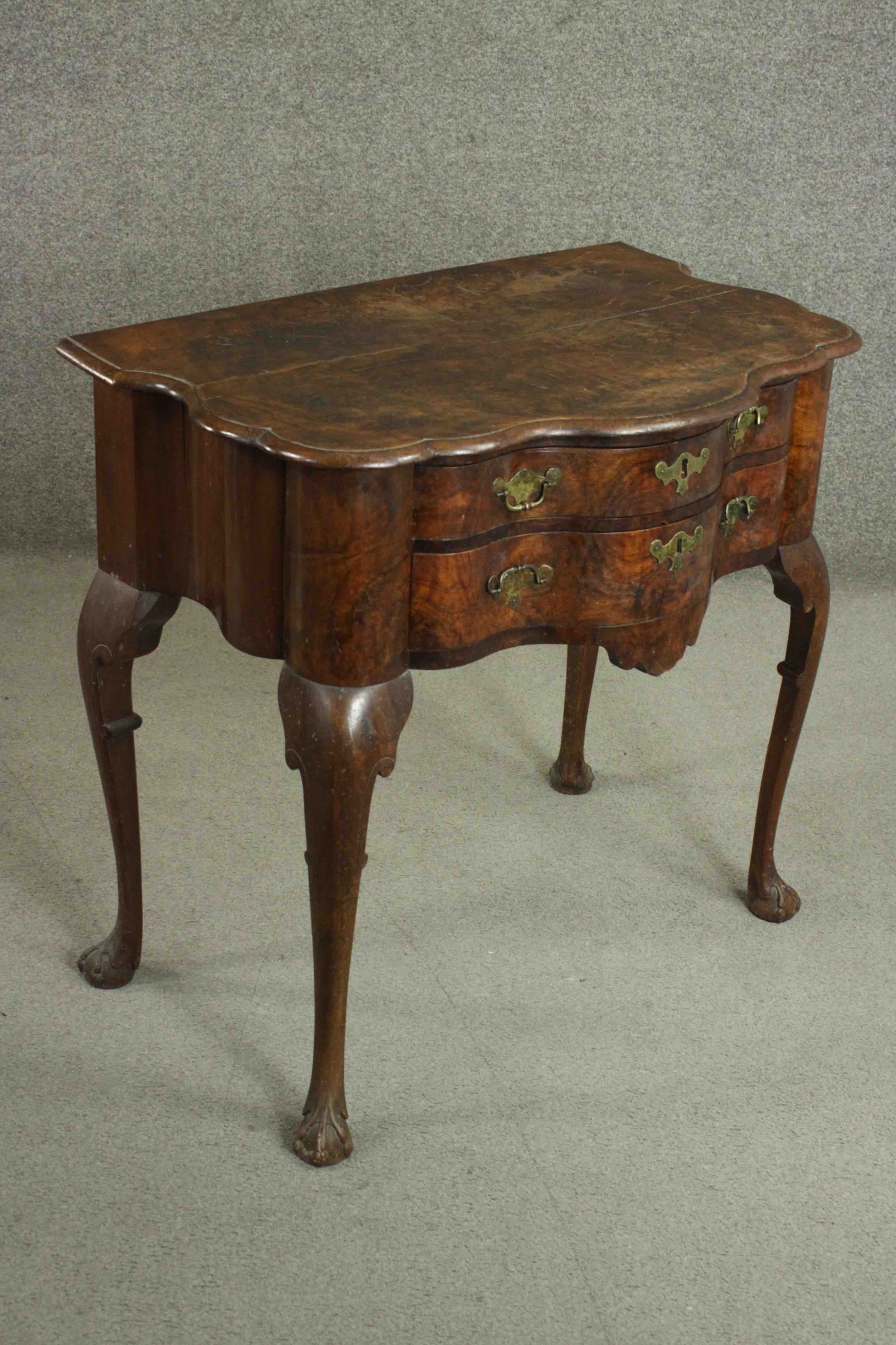 An early 18th century figured walnut lowboy of serpentine form, the top with a moulded edge over two - Image 3 of 8