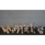 A collection of twenty five 19th and 20th century porcelain and ceramic figures, many of children or