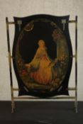 A circa 1900 brass framed and painted fire screen, the cartouche panel with decoupage depicting a