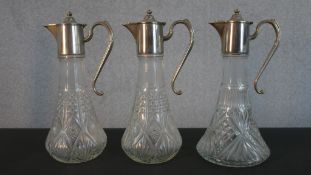 Three silver plated and pressed glass claret jugs, including a pair, all with matching mounts,