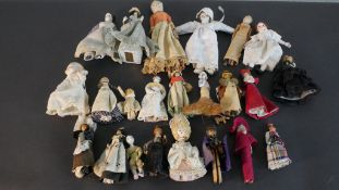 A collection of twenty three 19th and 20th century dolls, including two painted wooden peg dolls,