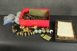 A collection of brass and iron door knobs and door hardware along with a mah-jong box and three