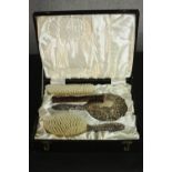 A boxed set of silver repousse scrolling and figural design brushes, mirror and comb. Hallmarked: