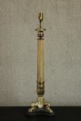 A 20th century brass table lamp of columnar form with a cast tri-form base with lion paw feet. H.